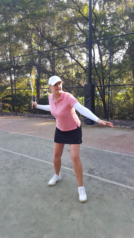 A woman about to hit a forehand tennis stroke wearing IceRays Sun Sleeves to protect her arms from the sun while playing tennis. Sun Protection!