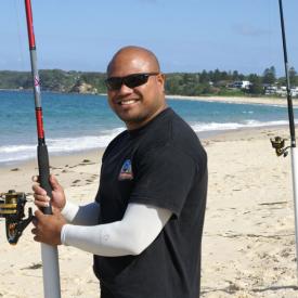 A man standing on the beach beside fishing poles wearing IceRays Sun Sleeves for Maximum sun protection while fishing. Fishing A man standing on the beach beside fishing poles wearing IceRays Sun Sleeves for Maximum sun protection while fishing. Fishing